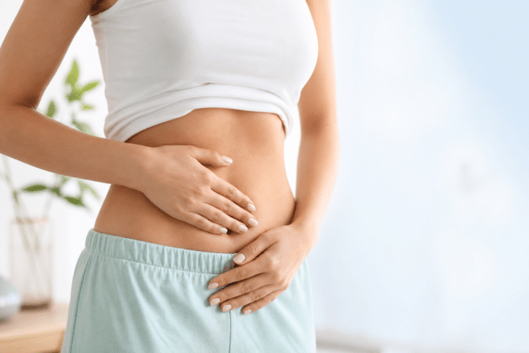 Frau greift mit Händen auf den Bauch